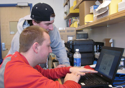 Students Jeff Pelkey (sitting) and Joe Frechette (standing) working on data analysis in the lab