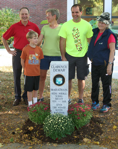Jay Kahn, Keene State VP for Finance and Planning (at left), is joined by Clarence DeMar’s granddaughter and great-grandson, race director Alan Stroshine, and Clarence DeMar's daughter, Betty DeMar-Mueller at the DeMar marathon finish line marker on Appian Way.
