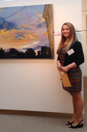 Courtney Lachaussie ’14 with one of her landscapes at the Bryan Memorial Gallery