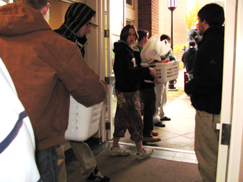 Fraternity members line up to load Thanksgiving Baskets into Keene State Trucks for delivery to the Community Kitchen for local WIC families. Photo by Colleen Pascu