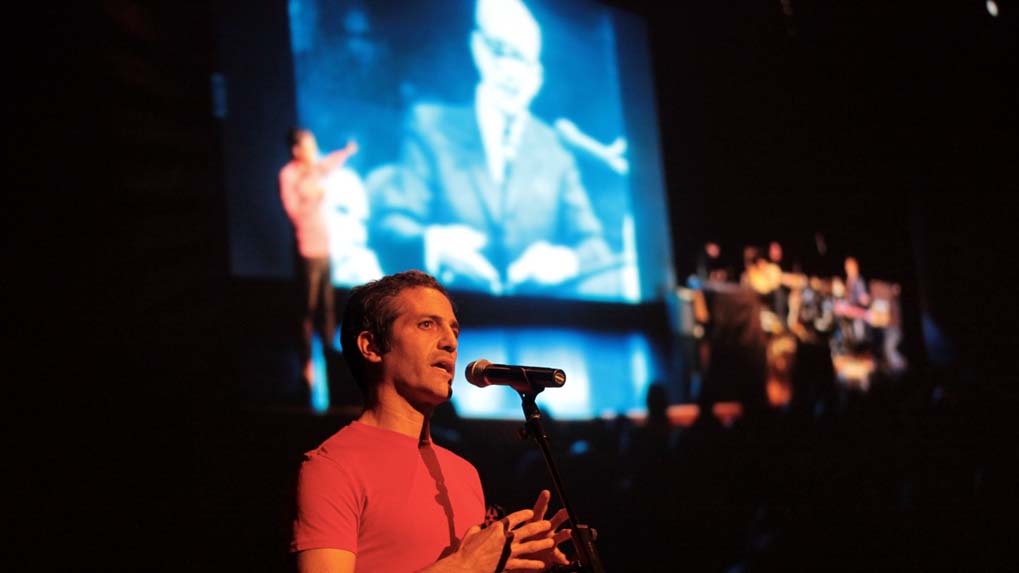 Sam Green, a documentary filmmaker, narrates during a screening of his film while a live band plays.