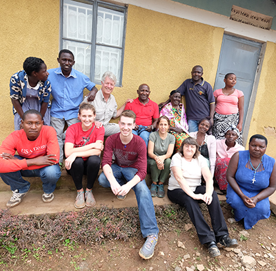 Architecture majors Rachel Lamica and Connor Bell with professors Donna Paley and Peter Temple at Father Roberts' home in Bucundura, Uganda. The woman in the white shirt and dark pants in the front row is a member of Father Roberts congregation at St. Bernard's Church, Ann Ball.