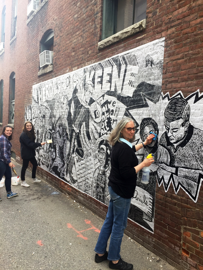 Rosemarie Bernardi and students install their mural in downtown Keene. Photo by Heather McGreer.