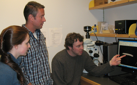 Brad Stubenhaus (at the computer) points out some of his findings on planarians to Emily Neverett and Dr. Pellettieri