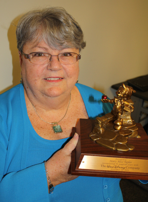 Walt Disney's costume buyer, Mary Alice Taylor ’78, holding the award she got for 35 years of loyal service.