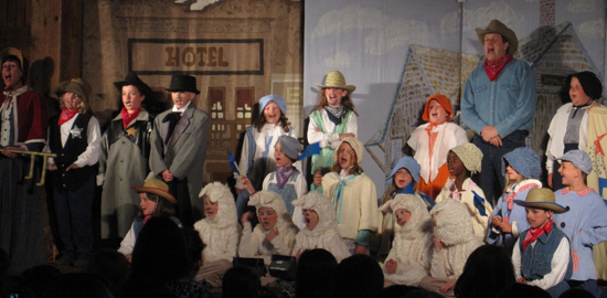 Lorrie Gray (far left) and Rob Gray ’88 (in blue shirt, red bandanna, and cowboy hat) with the troupe in &quot;Emperor&#039;s New Clothes&quot;