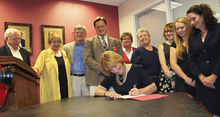 Gov. Hassan signs the Genocide Awareness Month legislation into law, flanked by Holocaust survivors and KSC leadership, faculty, students, and alums. (Lynn Roman photo)