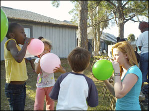 KSC junior Jessica Spellman plays with kids at a community outreach event at a low-income apartment complex in Orlando, Fla.
