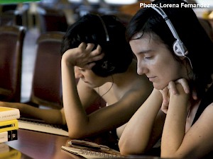 Two people follow instructions heard on headphones to participate in "The Quiet Volume."