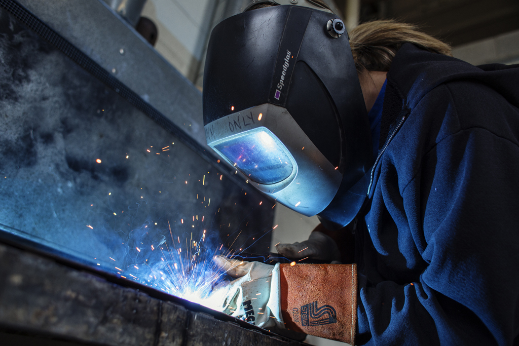 Associate Professor of Art Lynn Richardson, recipient of the 2015 Faculty Distinction in Research and Scholarship Award, welds in the studio. Photo by Will Wrobel.