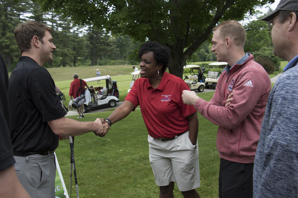 New Athletic Director Kristene Kelly (center) greets Tyler Hundley, assistant men's basketball coach, and Ryan Cain, head men's basketball coach, at the annual golf tournament. Photo by Will Wrobel