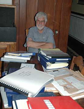 Dr. Larry Benaquist with just some of the records he delved into in his research to uncover the Sharps' heroic wartime efforts.