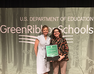 Dr. Karrie Kalich, dean of Professional and Graduate Studies (left), and Dr. Cary Gaunt, Director of Campus Sustainability, receive the Department of Education's Green Ribbon School Award.