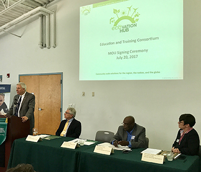 Dr. Todd Leach (left), Chancellor of USNH, speaking on behalf of Keene State College at the Ecovation Hub Education and Training Consortium's ceremonial MOU signing.