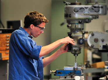 Student with drill press.