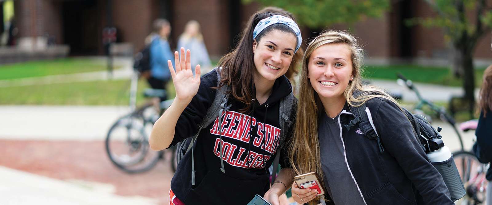 Students waving on Appian Way Fall