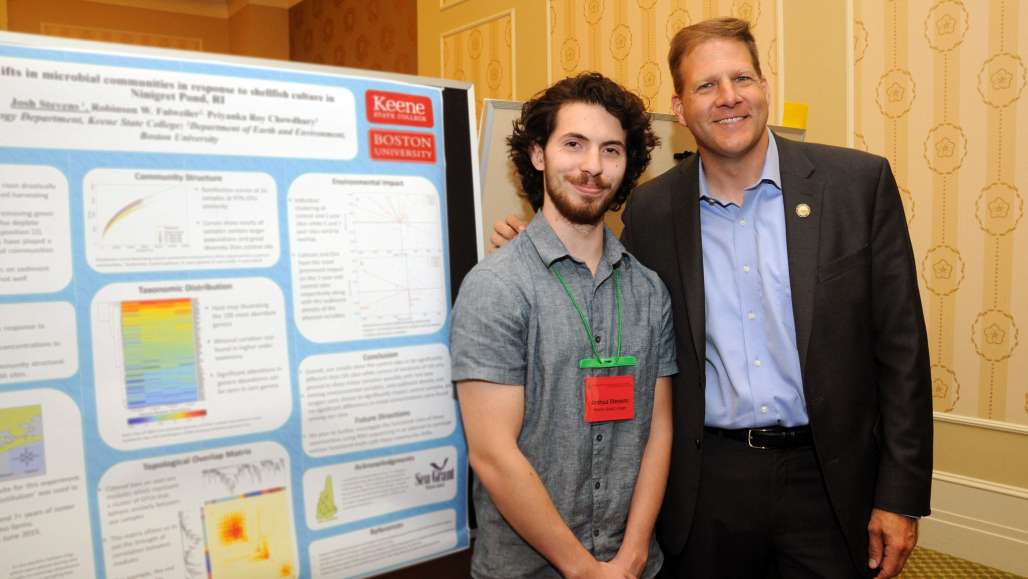 Student Joshua Stevens, with Governor Chris Sununu, presenting his poster “Shifts in microbial communities in response to shellfish culture in Ninigret Pond, RI