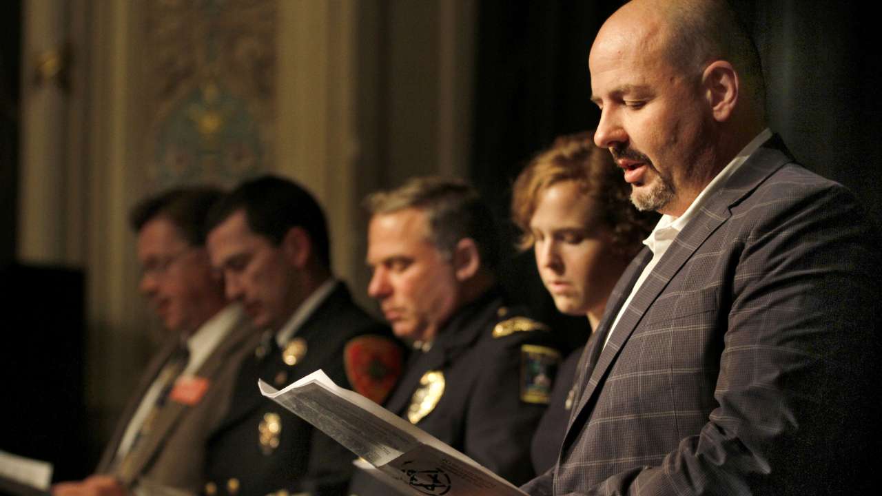 Man reading handout at event.