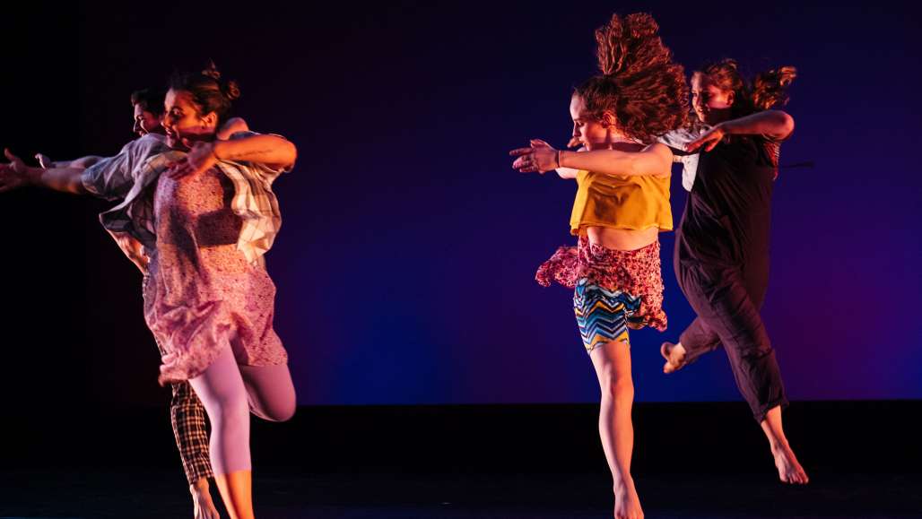 Grace Lonergan dances on the right in a yellow shirt.