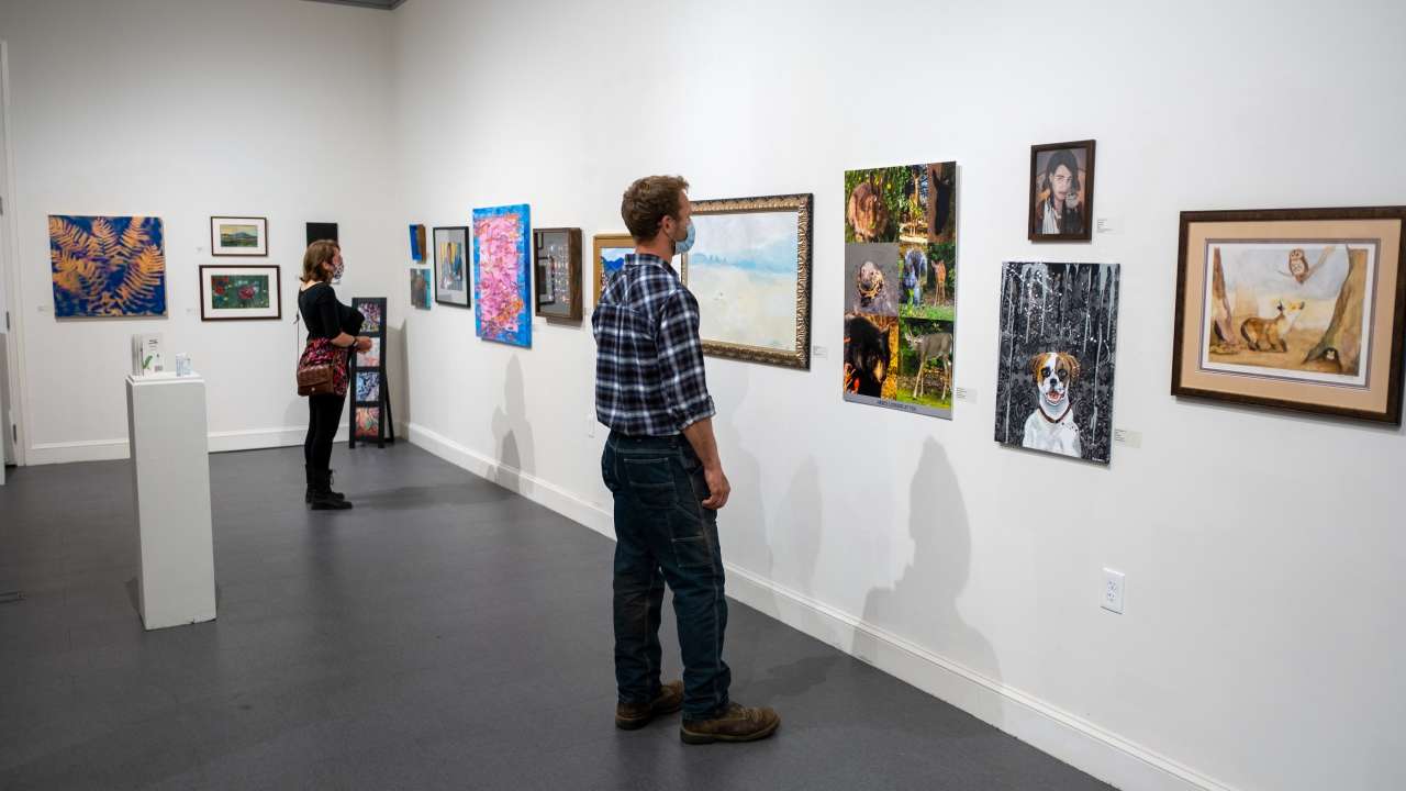Alumni View the Owls Fly Home Art Exhibit during Alumni Weekend 2021
