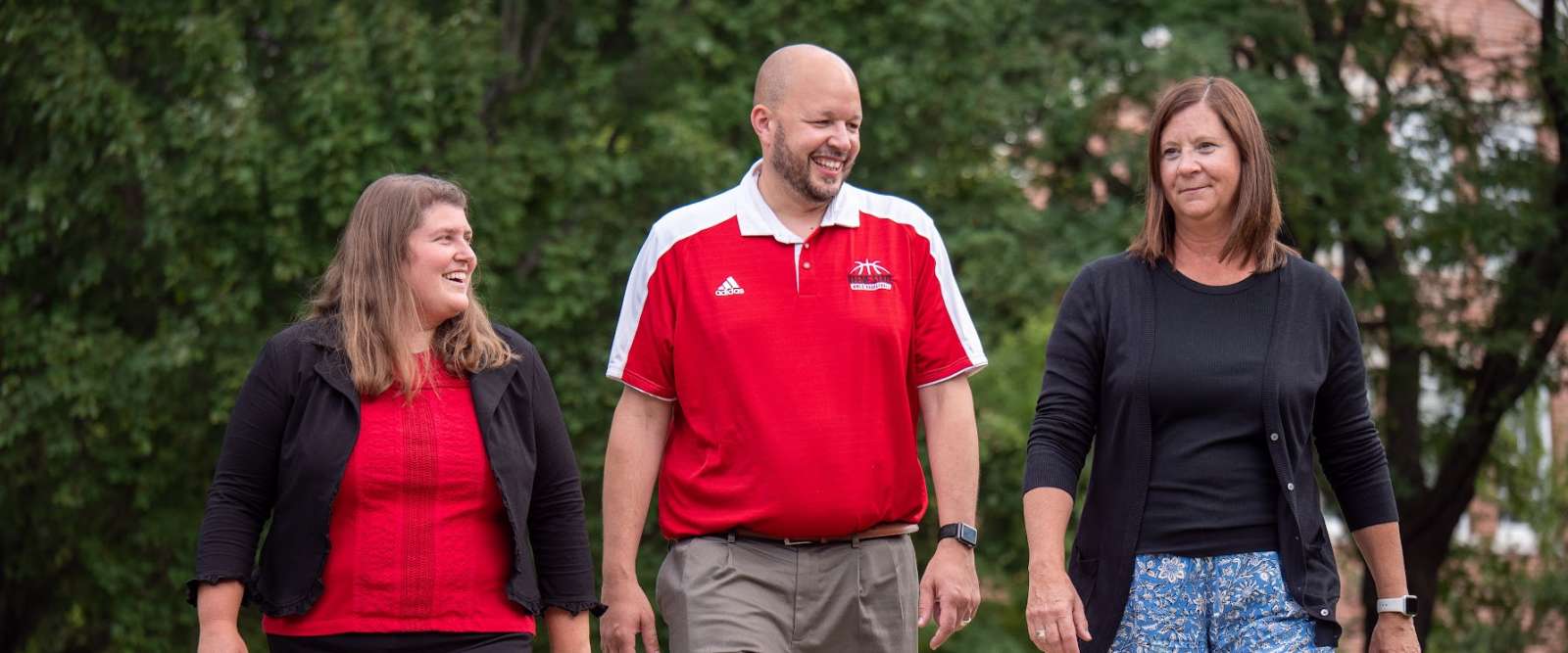 Three Admissions Counselors walk through campus