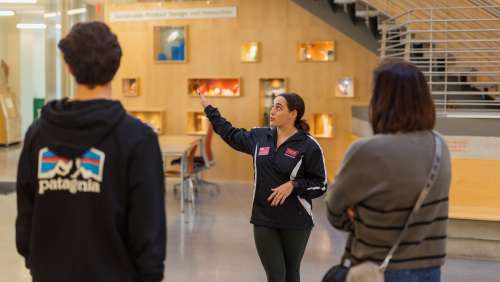 An student tour guide takes visitors on a campus tour