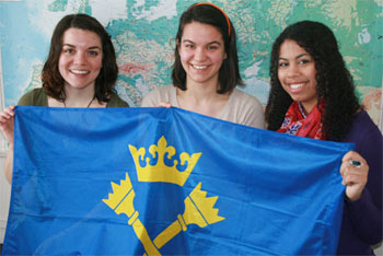 Holocaust and Genocide Studies students Johanna DeBari (left) and Chloe Edmonds (right) hold the Jagiellonian University flag with Justyna Jochym (middle) who coordinates the Jagiellonian study-away program.