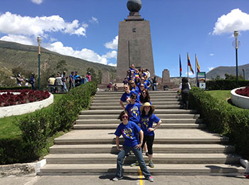 Students line up at 0 degrees to take photos at Mitad del Mundo