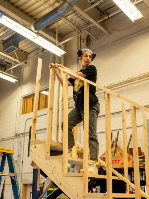 Ally Crisa in shop class standing on stairs