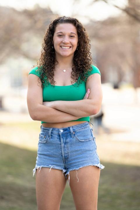 Student standing outside in shorts and t-shirt