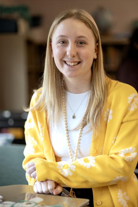 Smiling student wearing a yellow sweater with daisies