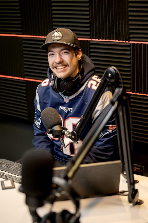 Student wearing Patriots football team jersey in podcast studio